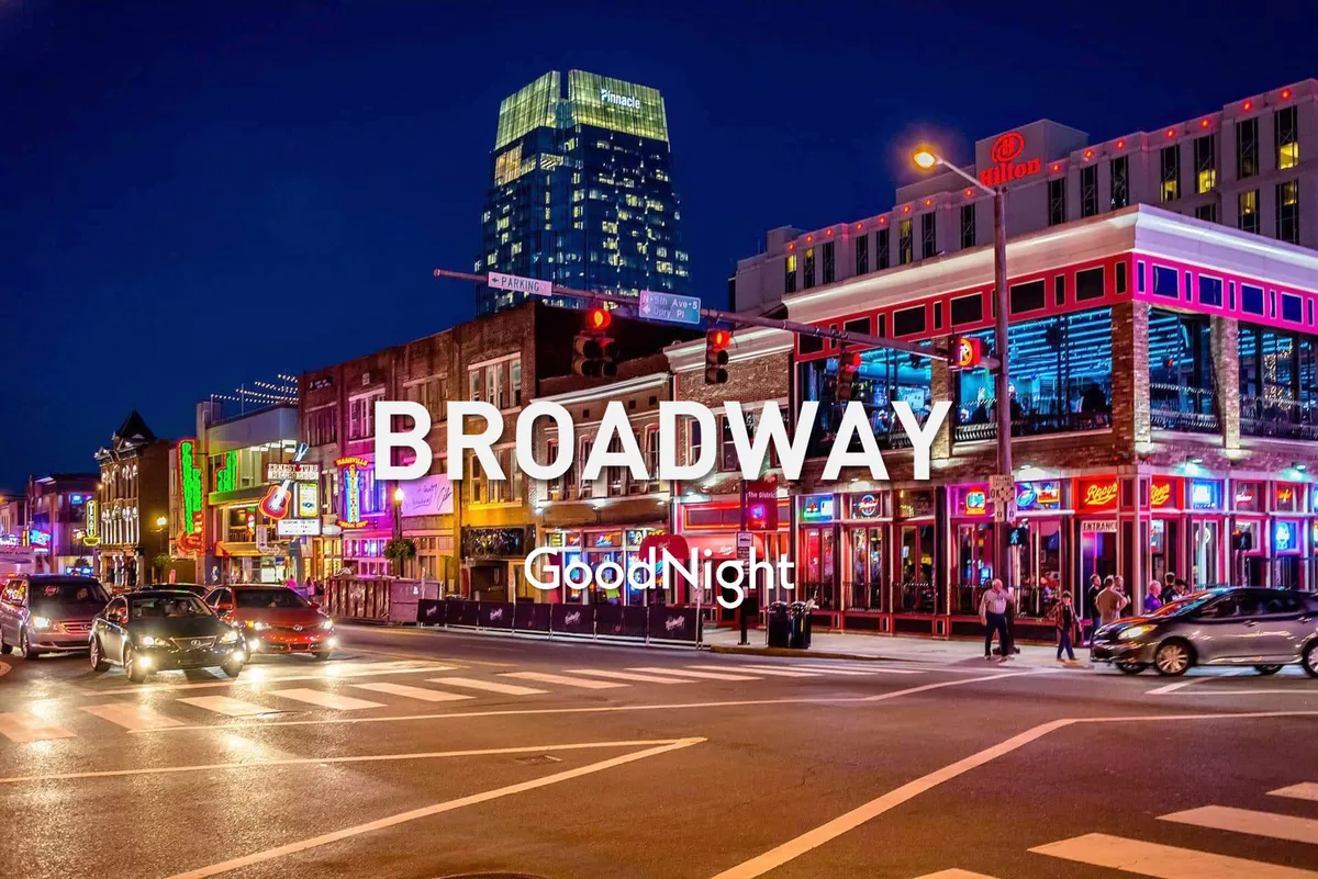 A vibrant city street at night crowded with people enjoying the nightlife, illuminated by neon lights and with high-rise buildings as a backdrop. The lively energy of the street is palpable, and the atmosphere suggests live performances, bustling bars, and a thriving downtown scene.